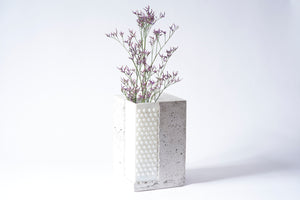 Bright stabel vase from Prasklo made from up-cycled glass material, a white chandelier, and cement, concrete. Individual single art piece