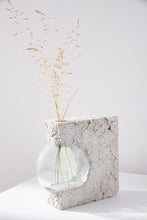 Load image into Gallery viewer, a vase made out of recycled glass and raw concrete set in white minimalistic interior on a table with decent flower.
